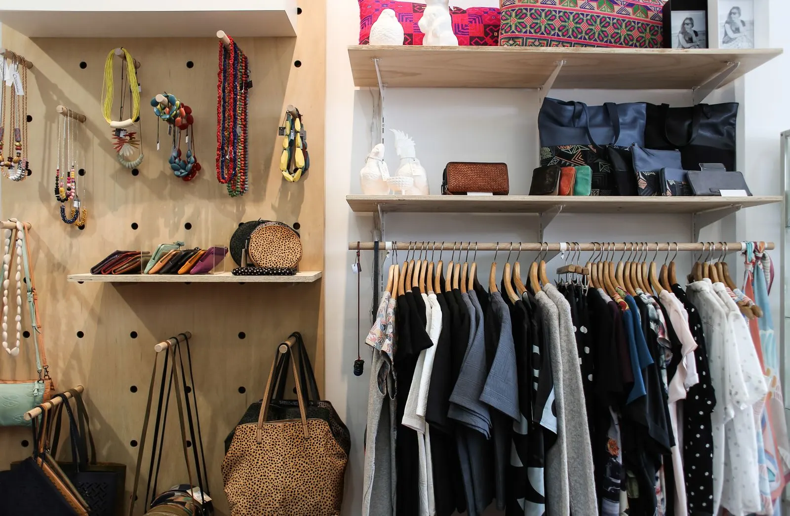 Een opgeruimde kledingkast met keurig gehangen kleding en tassen